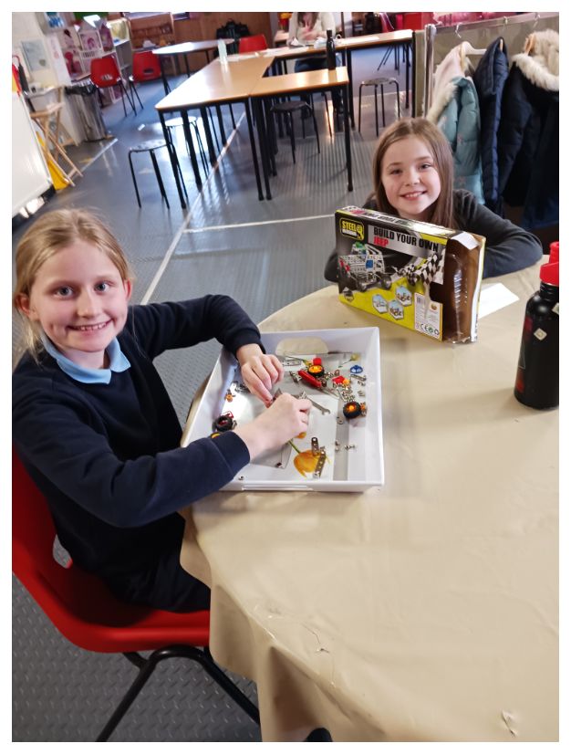 image of children sitting at table building lego